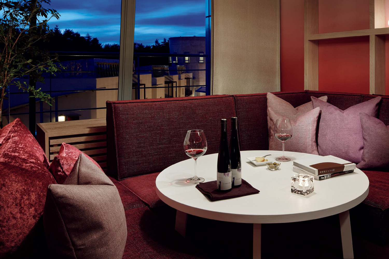 ワインスイートメゾネットの客室は、ボルドーカラーを基調にしたデザイン。リビングには、ゆったりとしたソファを配置。ワイングラスもそろっており、購入したワインを入れるワインセラーも。