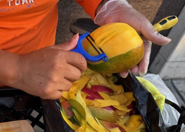 マンゴーをむいている女性