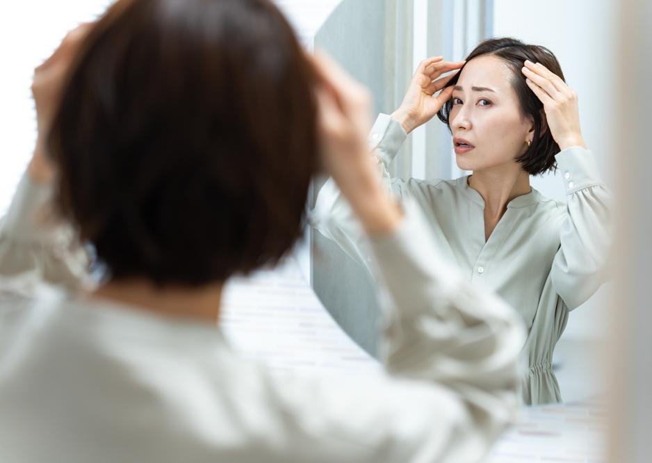 Beautiful,Woman,Looking,In,The,Bathroom,Mirror